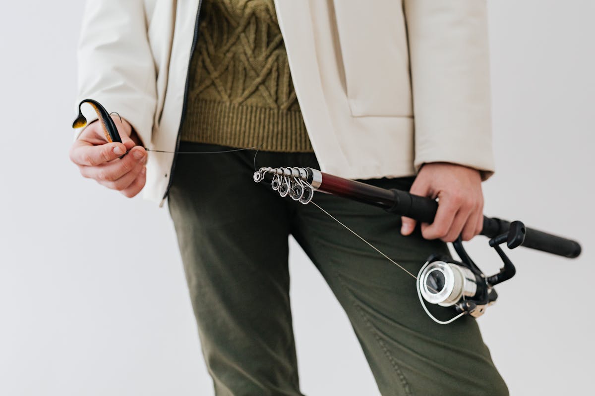 canne à pêche spinning tenue en main avec anneaux et moulinet