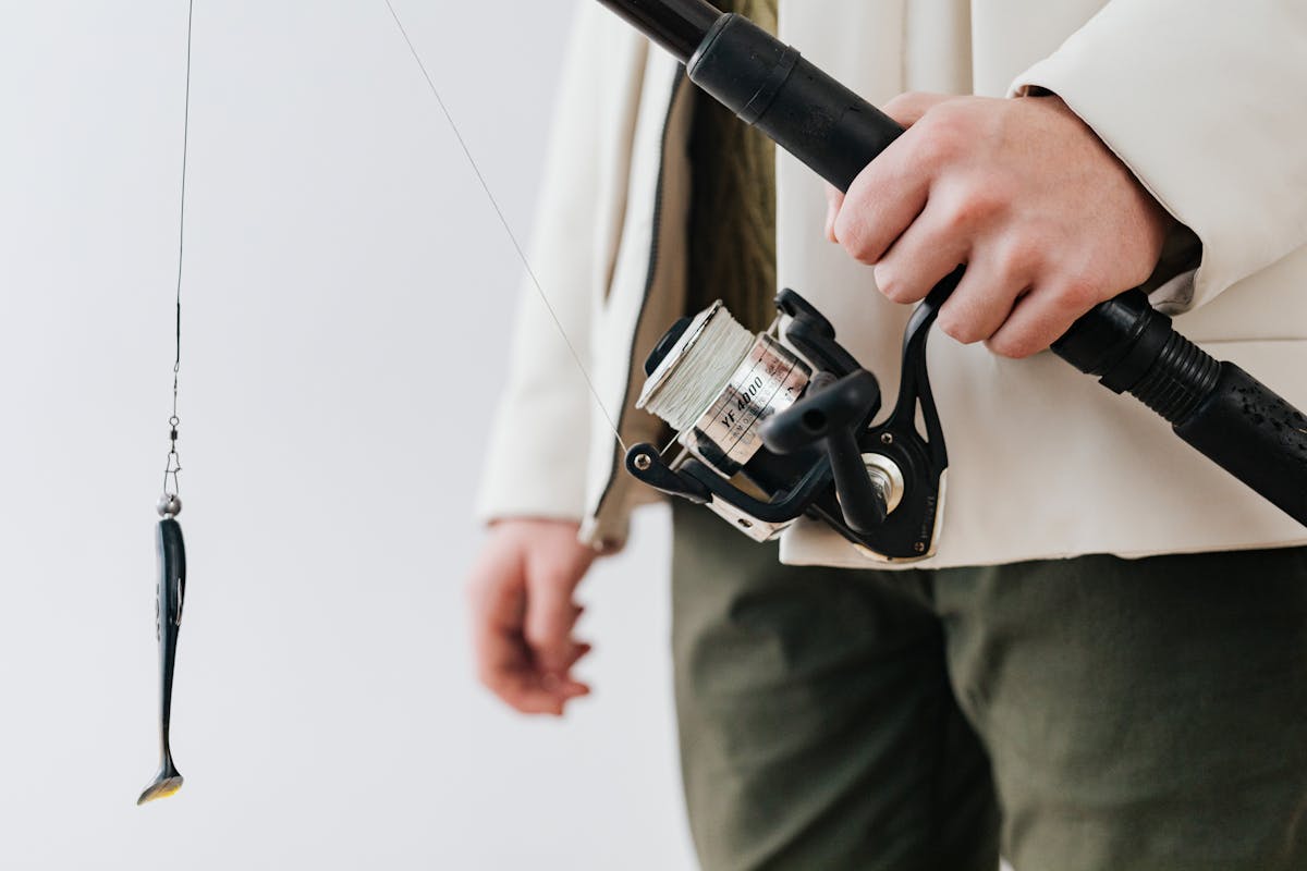 Pêcheur tenant une canne avec leurre souple et fil nylon - choix du fil de pêche