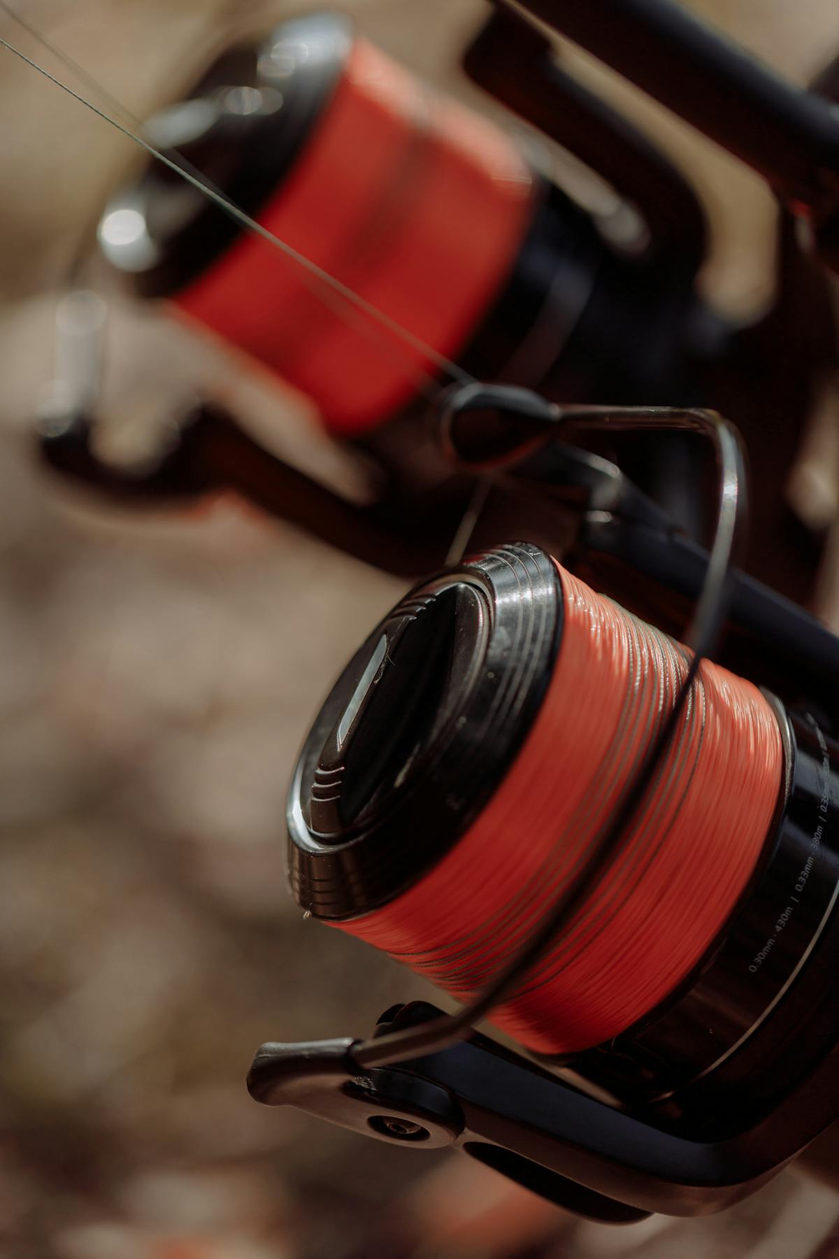 Gros plan de tresse rouge sur bobine de moulinet spinning - choisir sa tresse de pêche